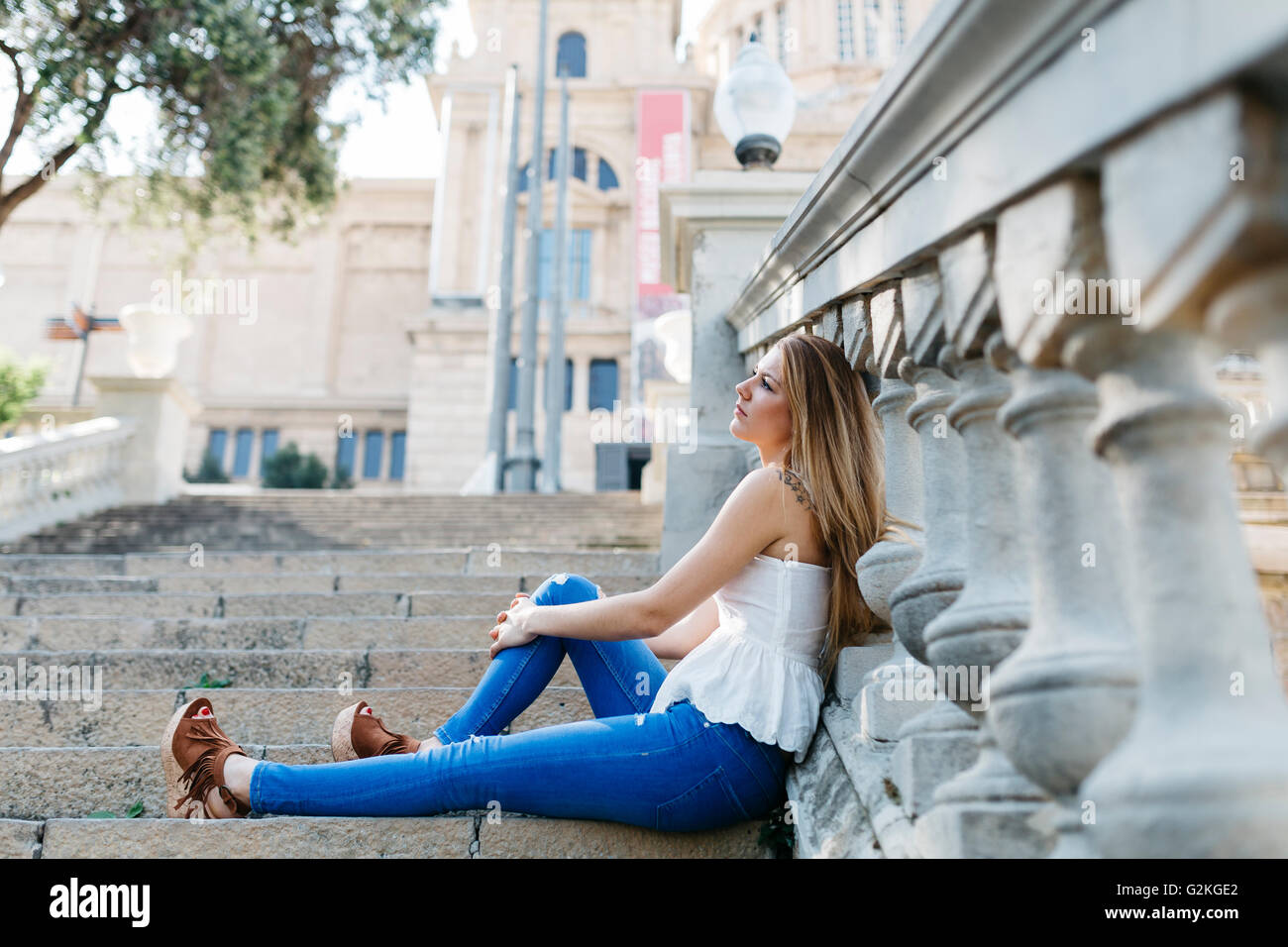 Espagne, Barcelone, jeune femme en faisant une pause, assis sur des escaliers Banque D'Images