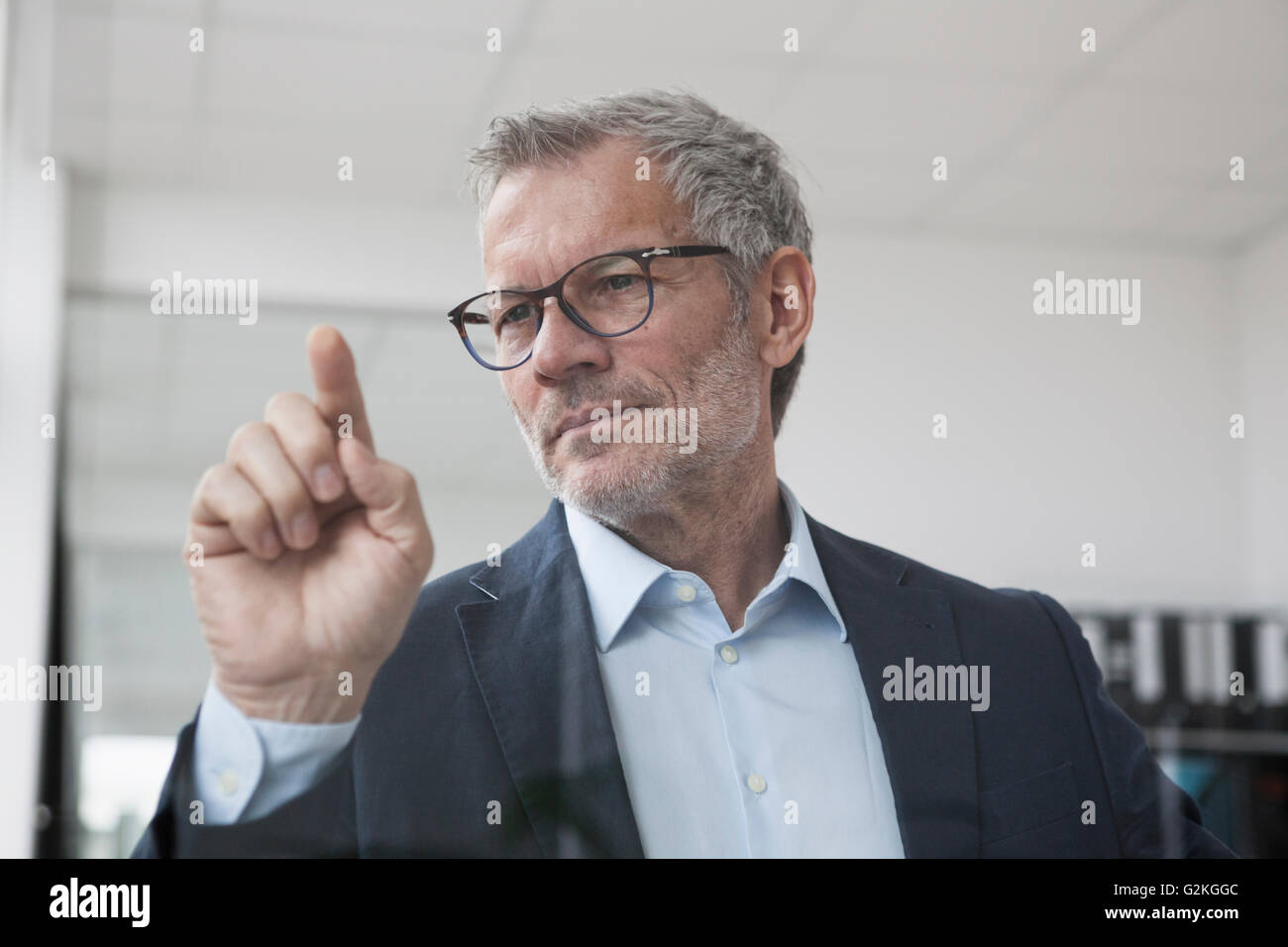 Successful businessman in office de toucher l'écran en verre Banque D'Images