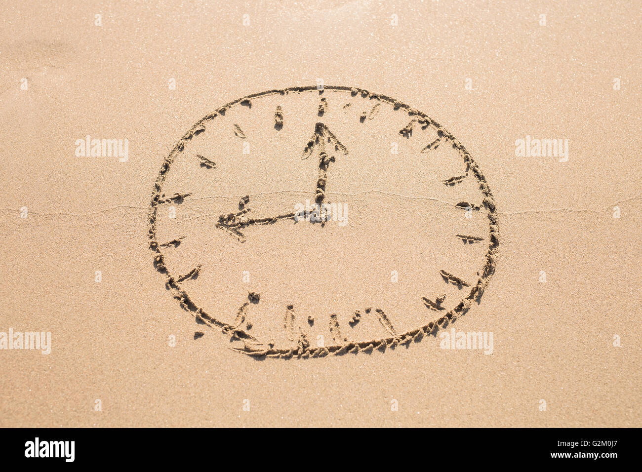 Concept de temps - Photo d'une horloge sur une plage de sable. Banque D'Images