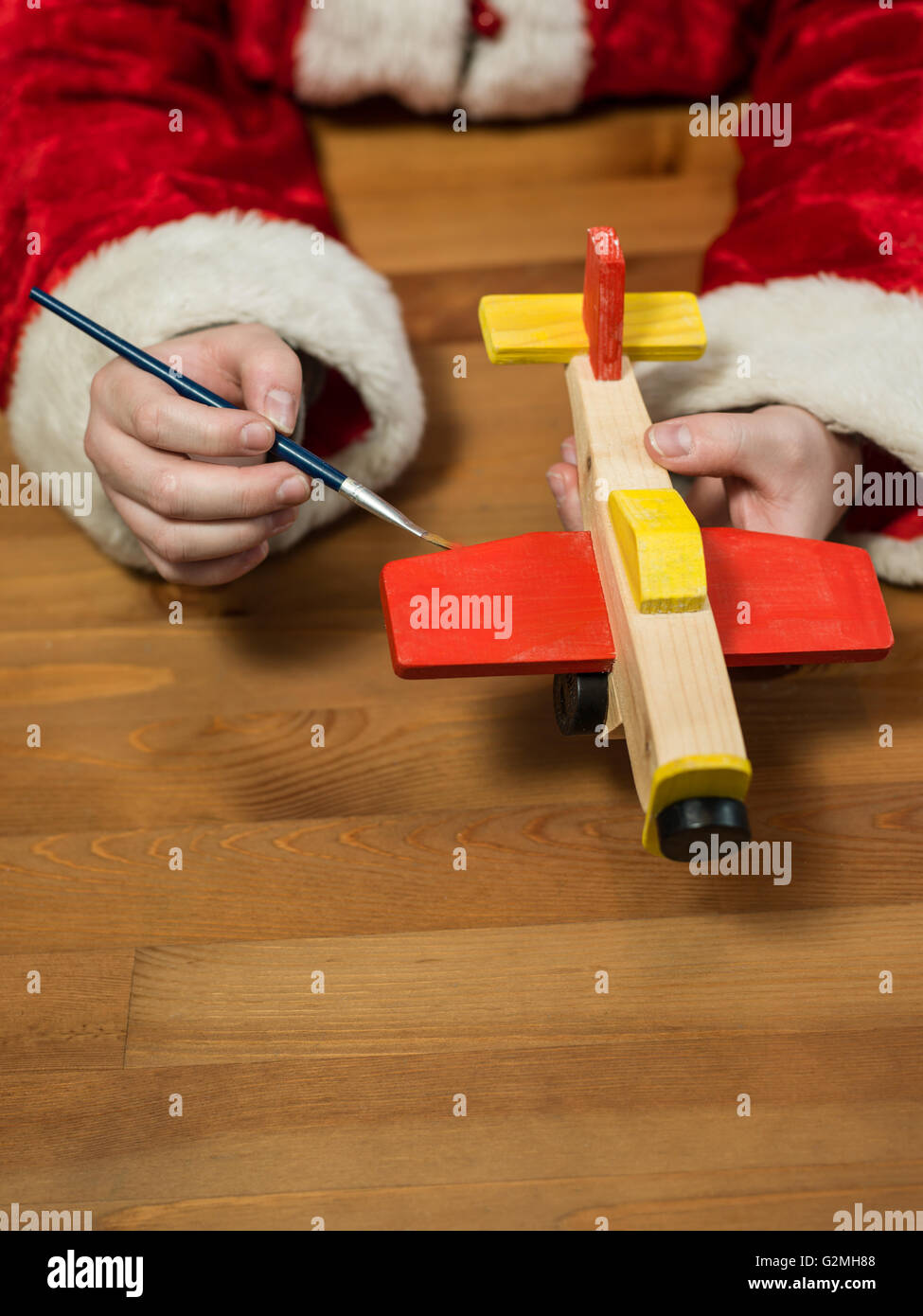Père Noël assis dans son atelier de peinture d'un avion jouet. Composition  horizontale Photo Stock - Alamy