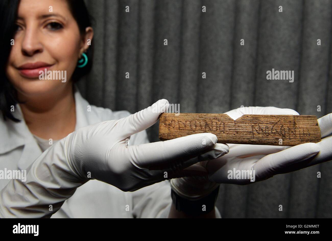 De 1200 sous embargo Mercredi 1 juin Luisa Duarte, un restaurateur pour le Musée de Londres, détient un morceau de bois avec les mots 'Londinio Mogontio' écrit dessus dans AD 65/80, qui est la première référence à Londres romain, trouvés lors des fouilles de Bloomberg's nouveau siège européen de la ville de Londres. Banque D'Images