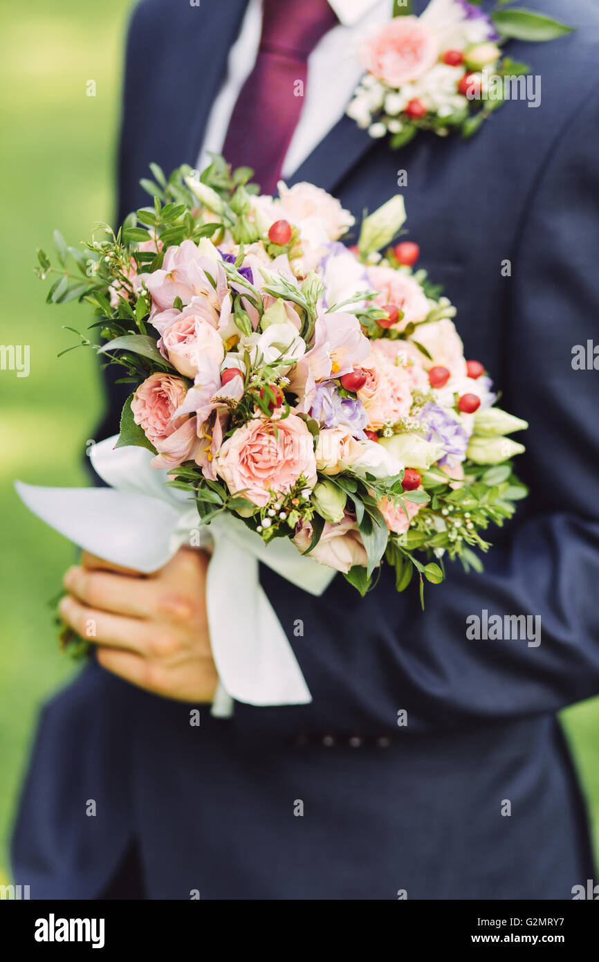 Groom holding roses bouquet, Close up Banque D'Images