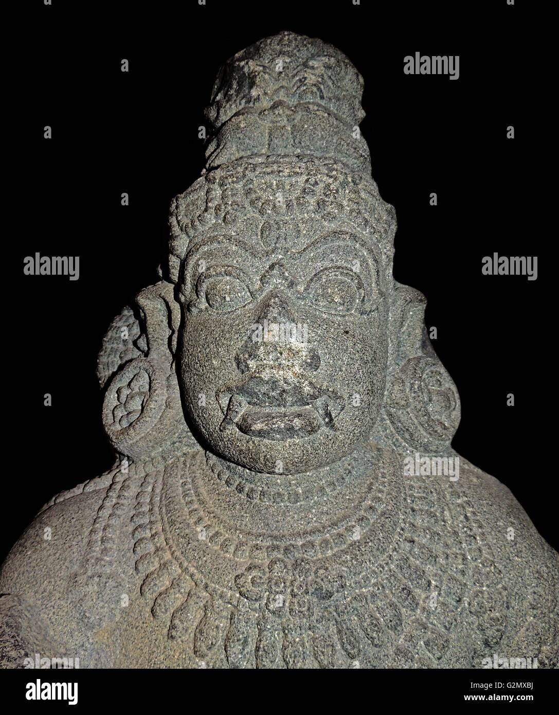 La figure de granit d'un dvarapala du Tamil Nadu, Inde du sud, la dynastie Chola, 12e siècle. Gardien de la porte d'un temple hindou. Le temple hindou est un espace sacré, un divin accueil pour les dieux lorsqu'il est appelé par leurs disciples. À la plupart des temples, sculptures de divinités et d'autres chiffres sont des endroits sur les murs extérieurs, dans des créneaux bien définis ou autour des portes. Ils apparaissent habituellement dans les paires de chaque côté de la porte, vers l'intérieur pour protéger l'enceinte sacrée du temple de forces malveillantes. Banque D'Images