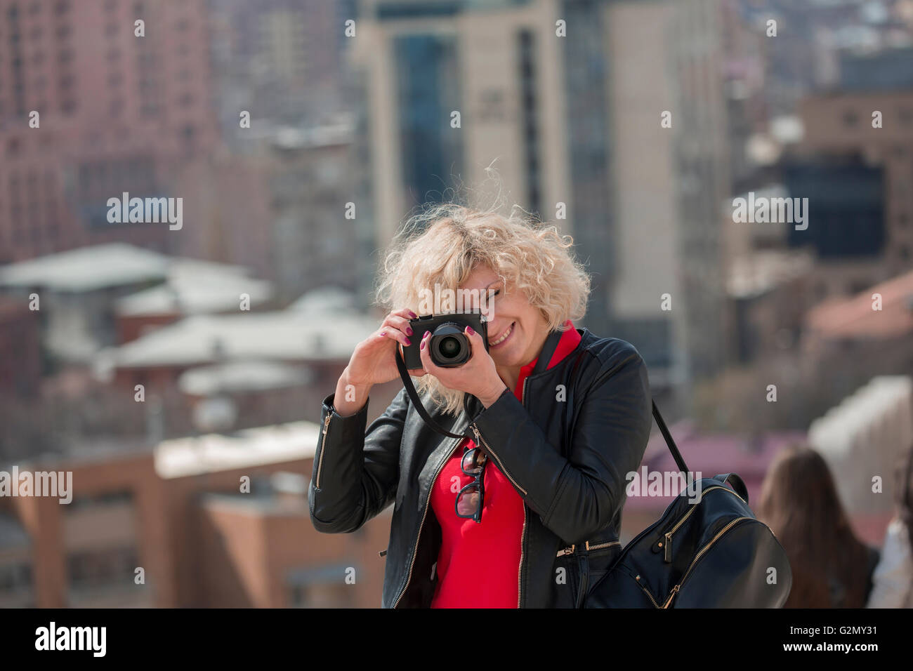 Belle femme blonde avec des cheveux bouclés fait photo Banque D'Images