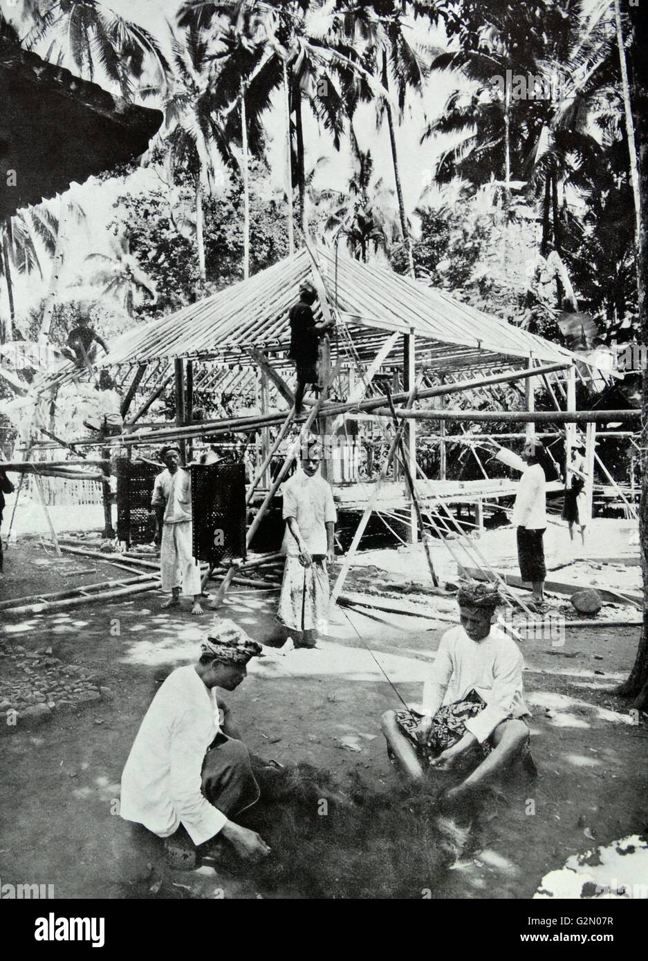 La photographie montre un groupe de personnes de construire une maison dans une forêt. Dutch East Indies, connu sous le nom de l'Indonésie moderne. Du c1935 Banque D'Images