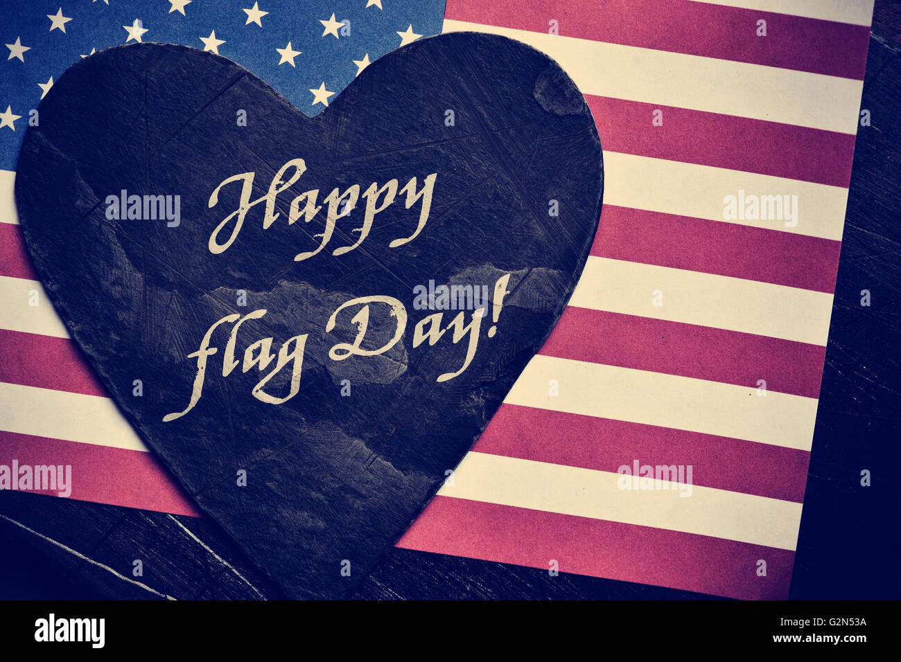 Le texte heureux le jour du drapeau écrit dans une ardoise en forme de coeur et un drapeau des États-Unis dans l'arrière-plan, avec un rétro ef Banque D'Images
