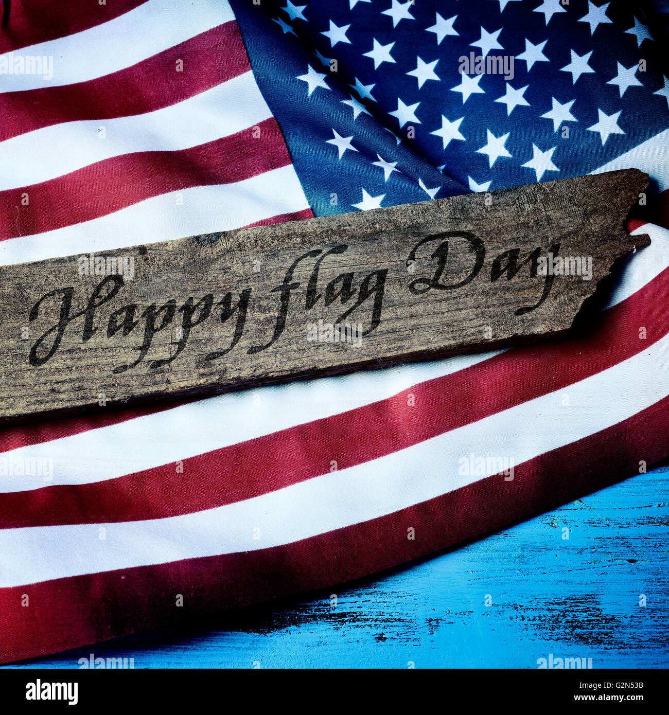 Le texte heureux le jour du drapeau écrit dans un vieux bois board et un drapeau des États-Unis dans l'arrière-plan Banque D'Images