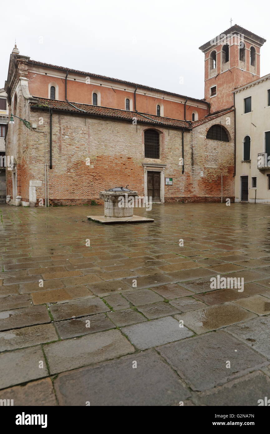 Église catholique de Venise, en Italie, un jour de pluie, avec un puits dans sa cour Banque D'Images