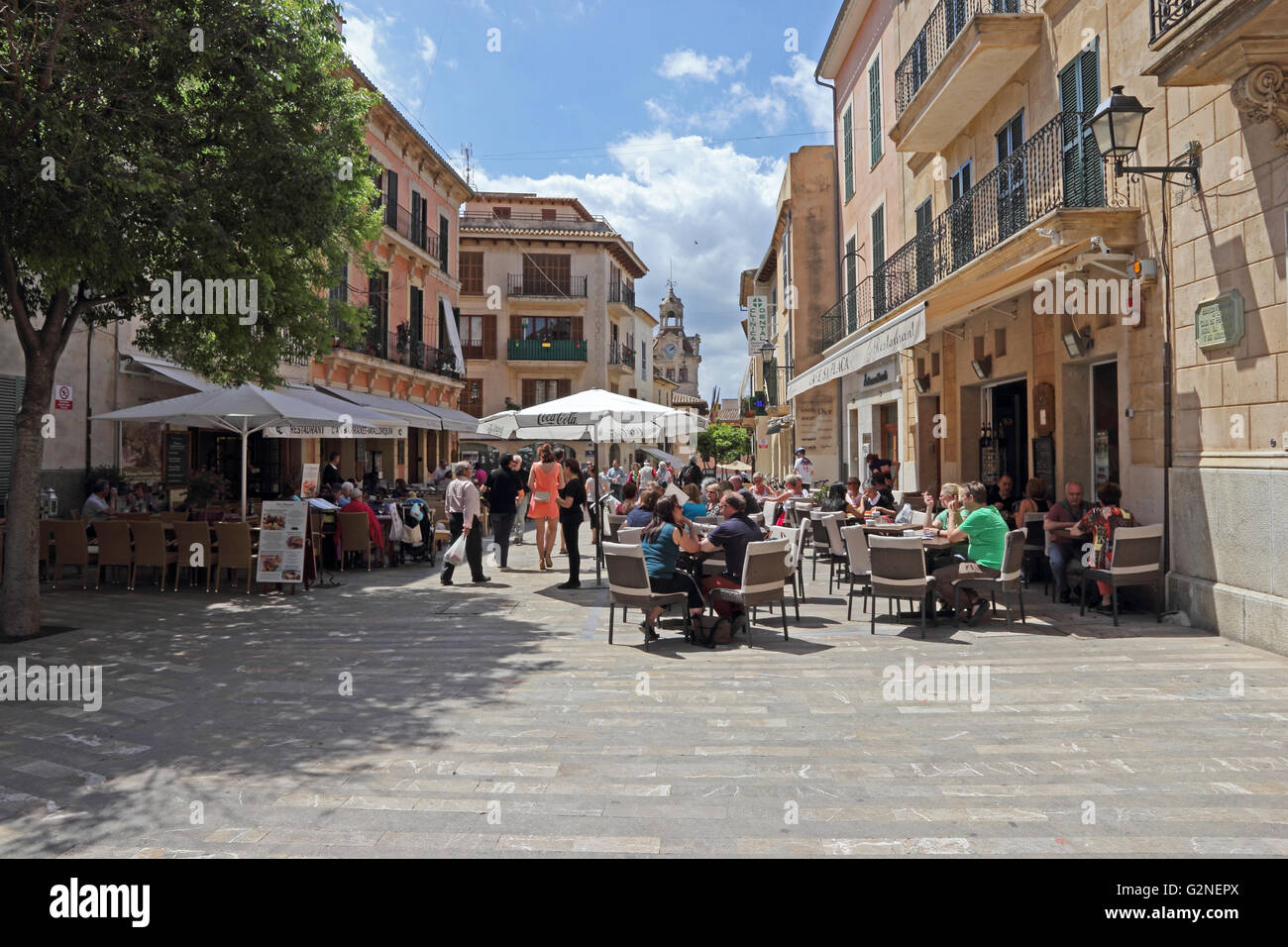 Les gens assis à l'extérieur des cafés dans la Placa de la Constitució, Alcudia, Majorque Banque D'Images