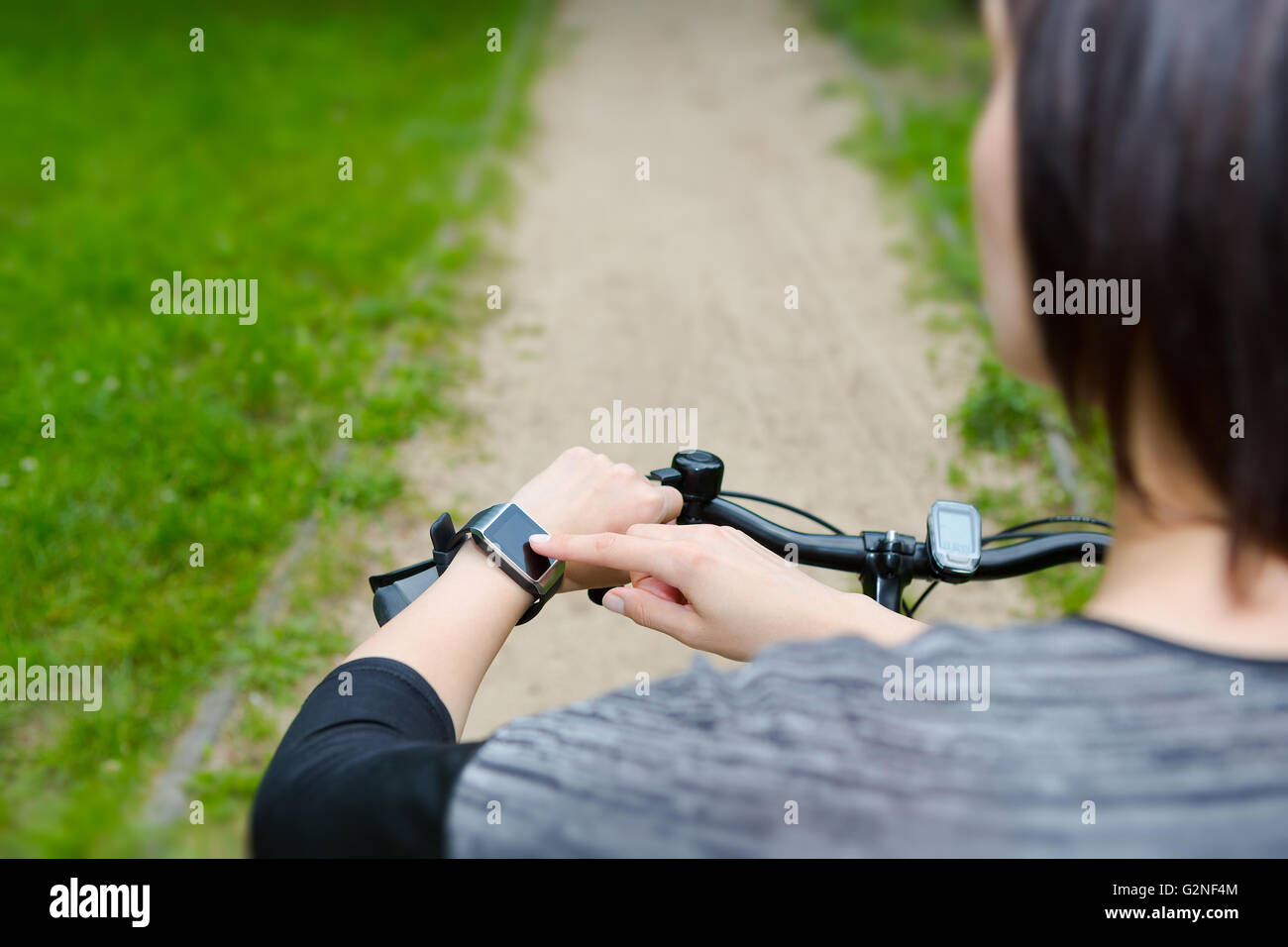 Woman riding a bike smartwatch avec un moniteur de fréquence cardiaque. Smart watch concept. Banque D'Images