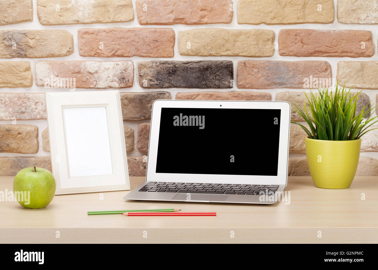 Travail de bureau avec ordinateur portable et photo frame en face du mur de briques. Style loft Banque D'Images