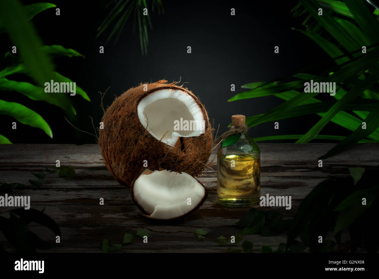 Vue rapprochée de l'huile de noix de coco fraîche et agréable sur l'arrière-plan de la feuille verte Banque D'Images