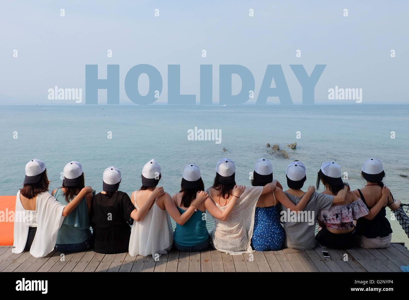 Groupe de dix femmes amis s'asseoir ensemble rechercher MAISON DE VACANCES hug mer ciel Banque D'Images