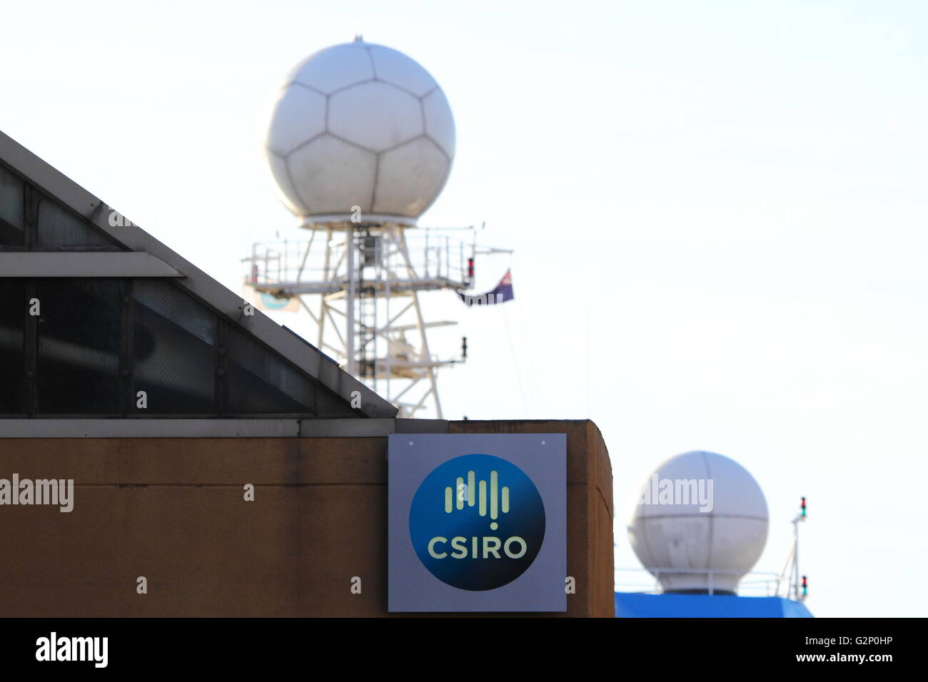 Dômes radar et satellite à bord du CSIRO Marine National 'Installation' enquêteur RV poke de derrière un bâtiment. Banque D'Images