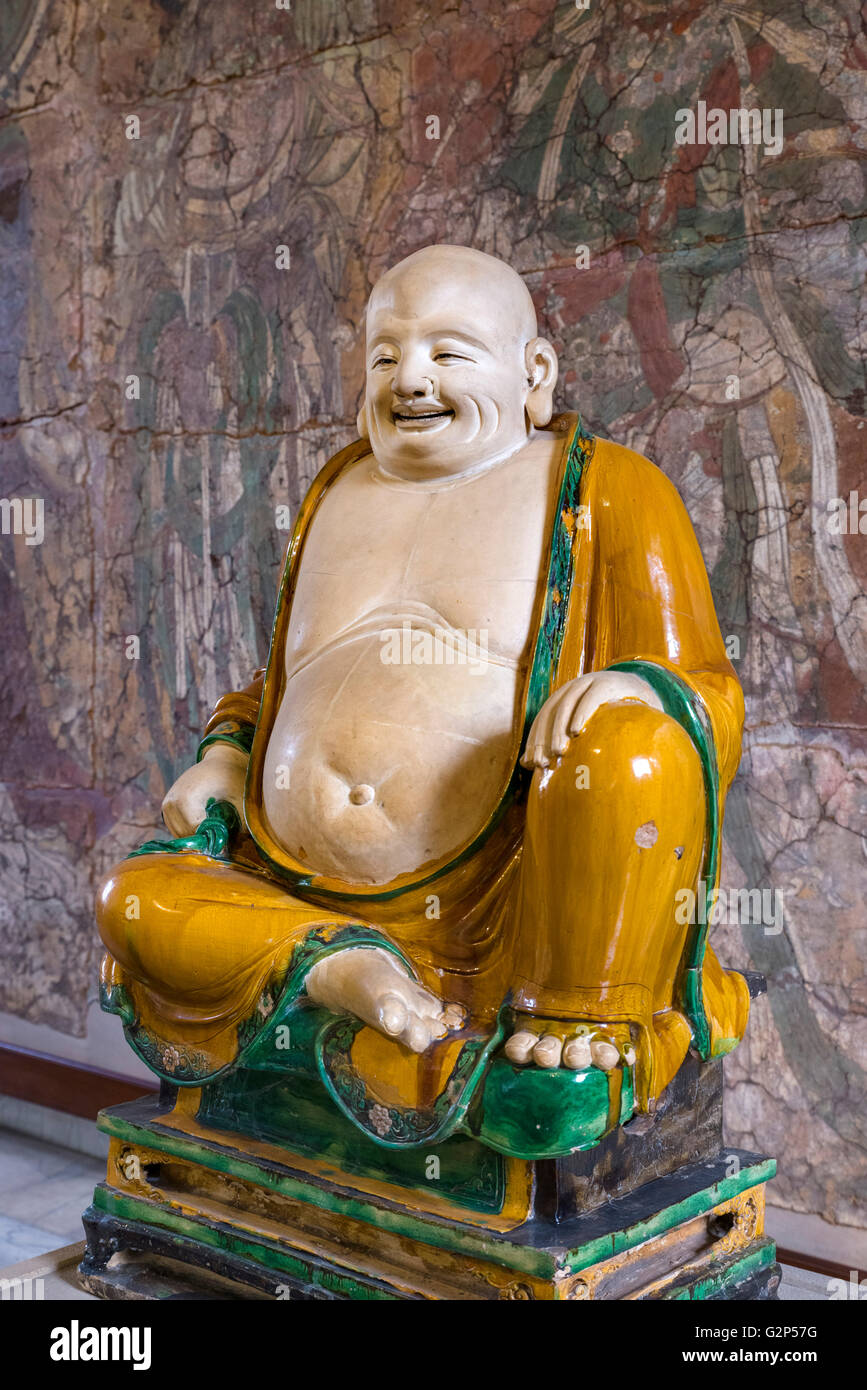 La figure de grès Budai Hesheng, une déité folklorique chinois. Son nom signifie "sac en tissu, et vient de le sac qu'il est conventionnellement représenté comme l'exercice. Il est habituellement identifié avec ou considéré comme une incarnation de Maitreya, le futur Bouddha, si bien que l'image Budai est l'une des principales formes que Maitreya est représenté en Chine. Dynastie Ming, période, 1486 Xinian Square. Affiché dans le British Museum, Bloomsbury, London, England, UK Banque D'Images