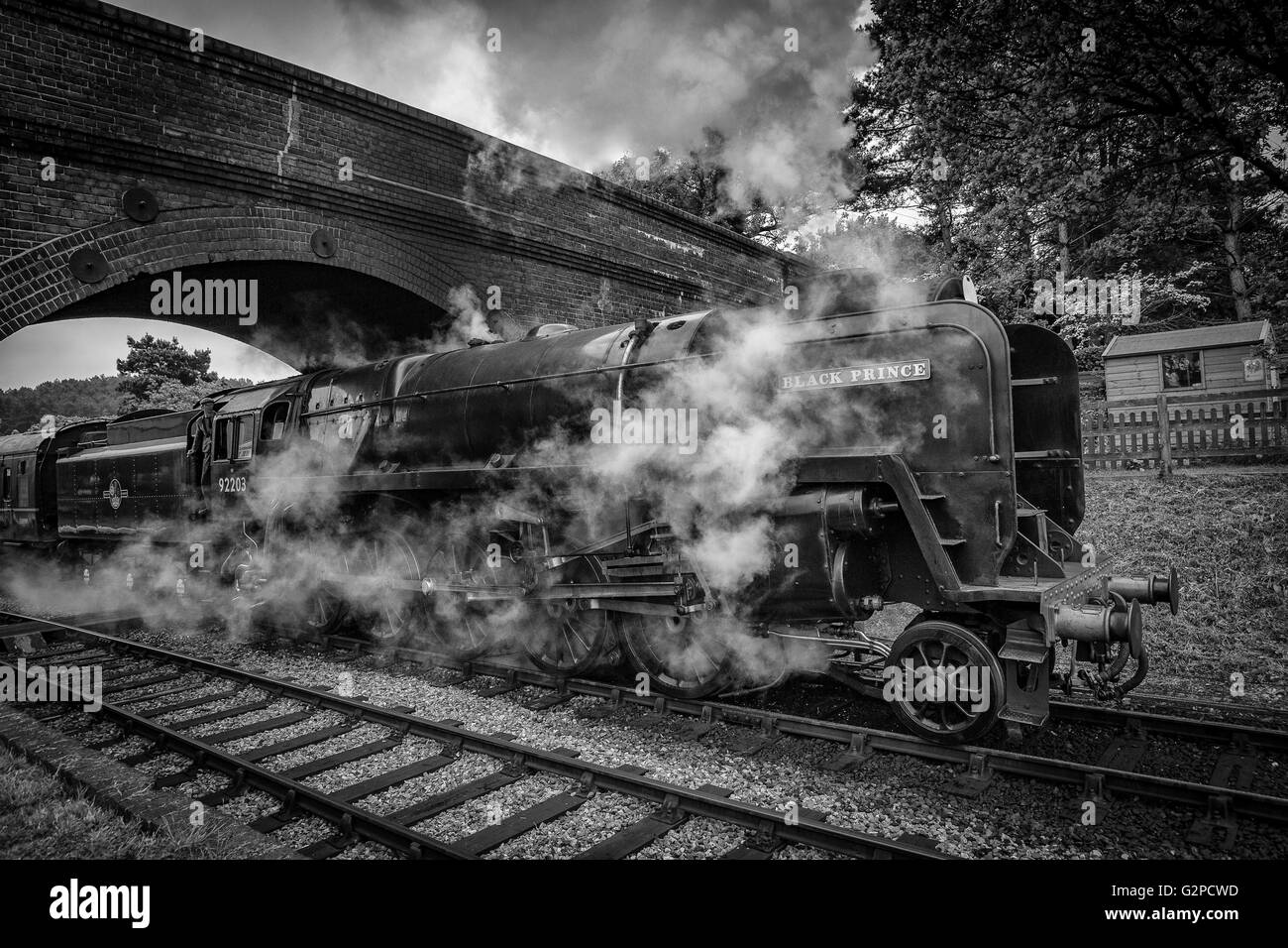 Train à vapeur passant sous un pont sur le chemin de fer North Norfolk Banque D'Images