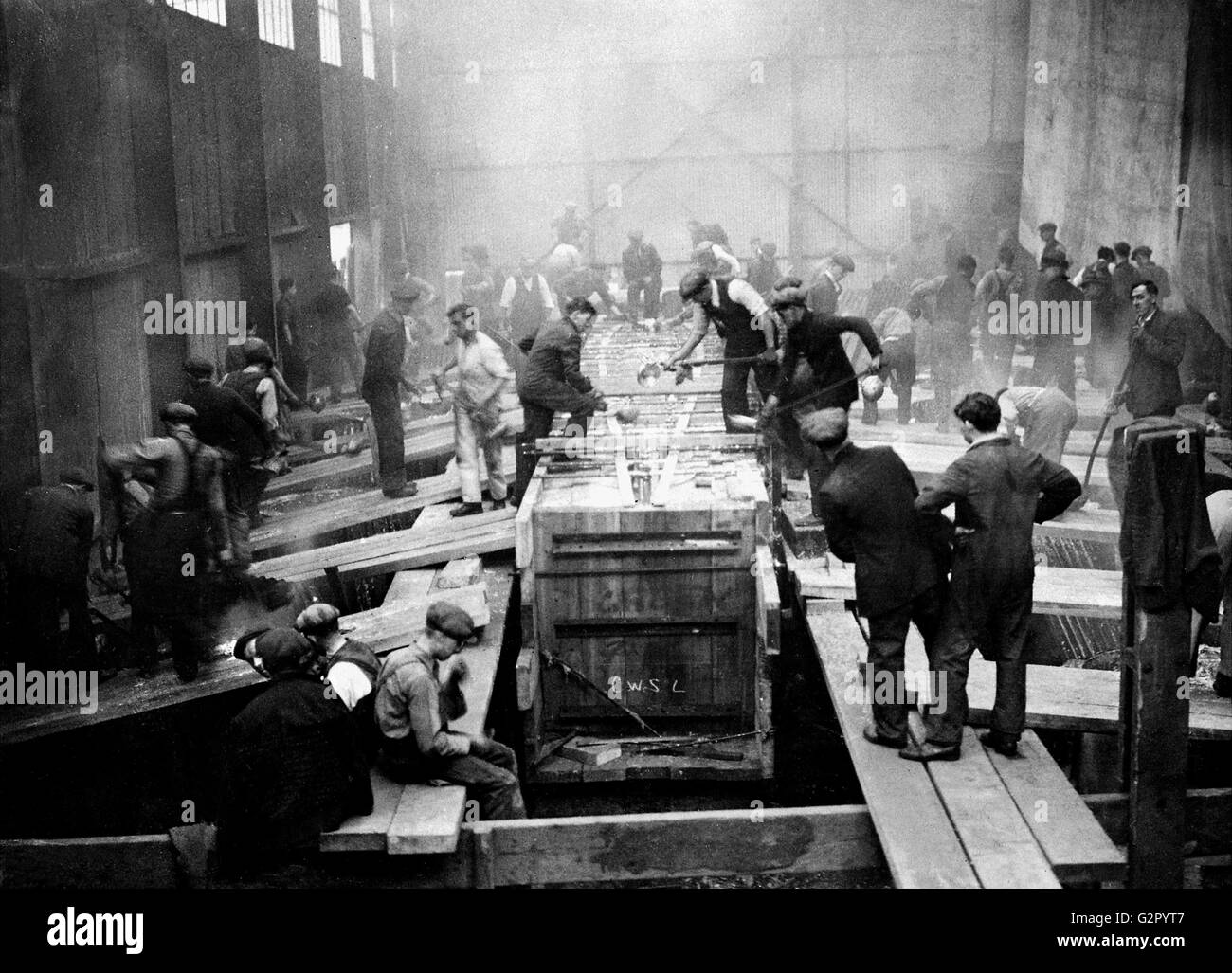 AJAXNETPHOTO. 1930S. GOSPORT, Angleterre. - Les TRAVAILLEURS DE LA COUR CAMPER & NICHOLSON CHAUD COULER DU PLOMB DANS LA QUILLE MOULE DE L'YACHT CLASSE J VELSHEDA EN CONSTRUCTION. PHOTO:AJAX VINTAGE PHOTO LIBRARY REF:HDD   1930 YA VELSHEDA Banque D'Images