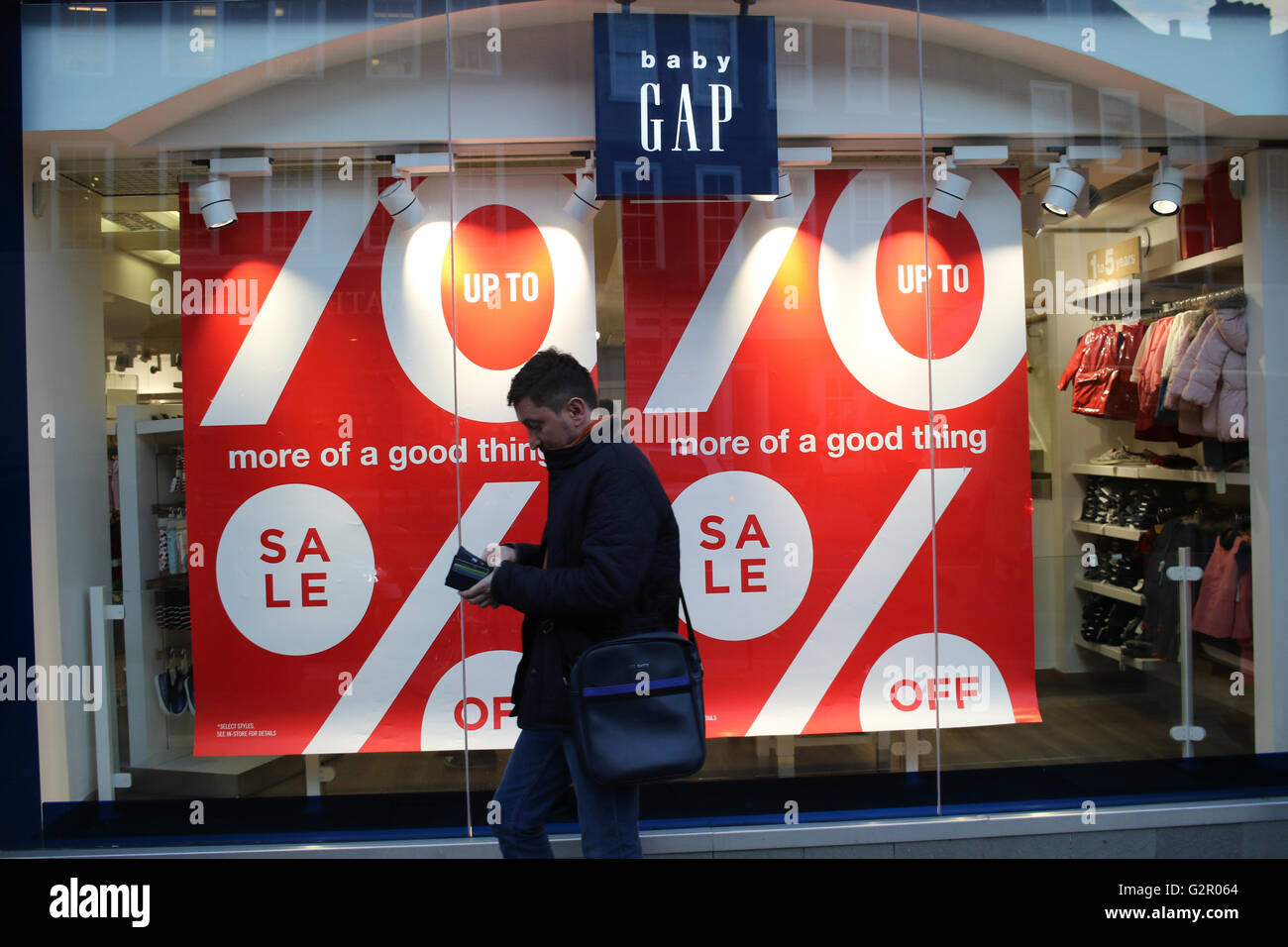 Homme marche passé 70  % off vente signe à un magasin de vêtements Gap Bébé Banque D'Images