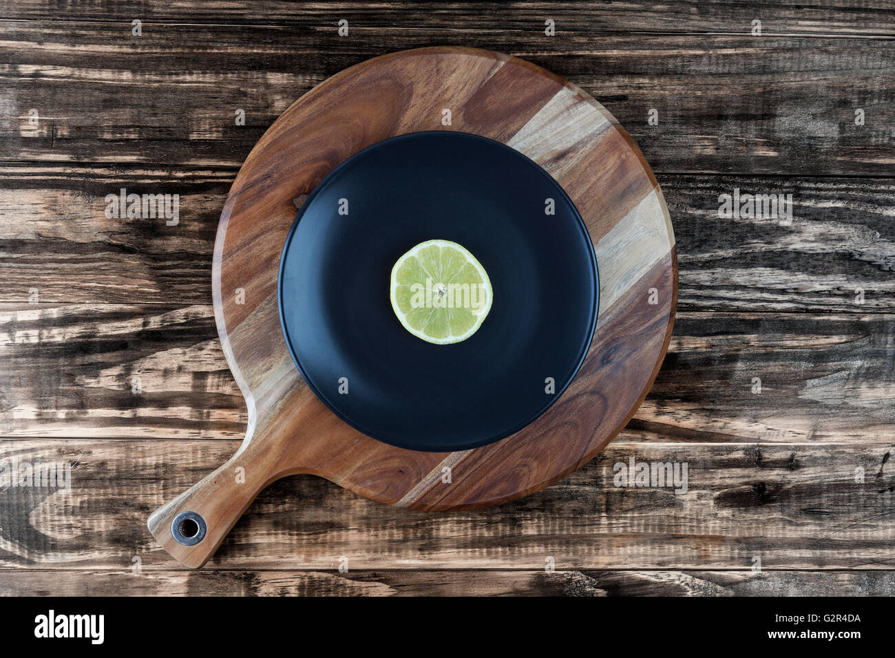 Tranche de citron sur la plaque noire et planche à découper ronde. Ressemble à l'enregistrement de musique en vinyle. Vue de dessus avec l'exemplaire de l'espace. Banque D'Images
