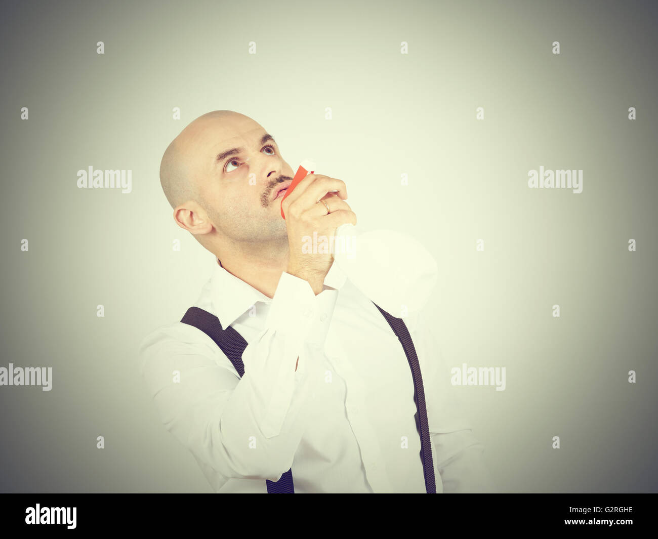 Homme chauve travailleur nettoyage détergent liquide de pulvérisation en face de lui, Banque D'Images