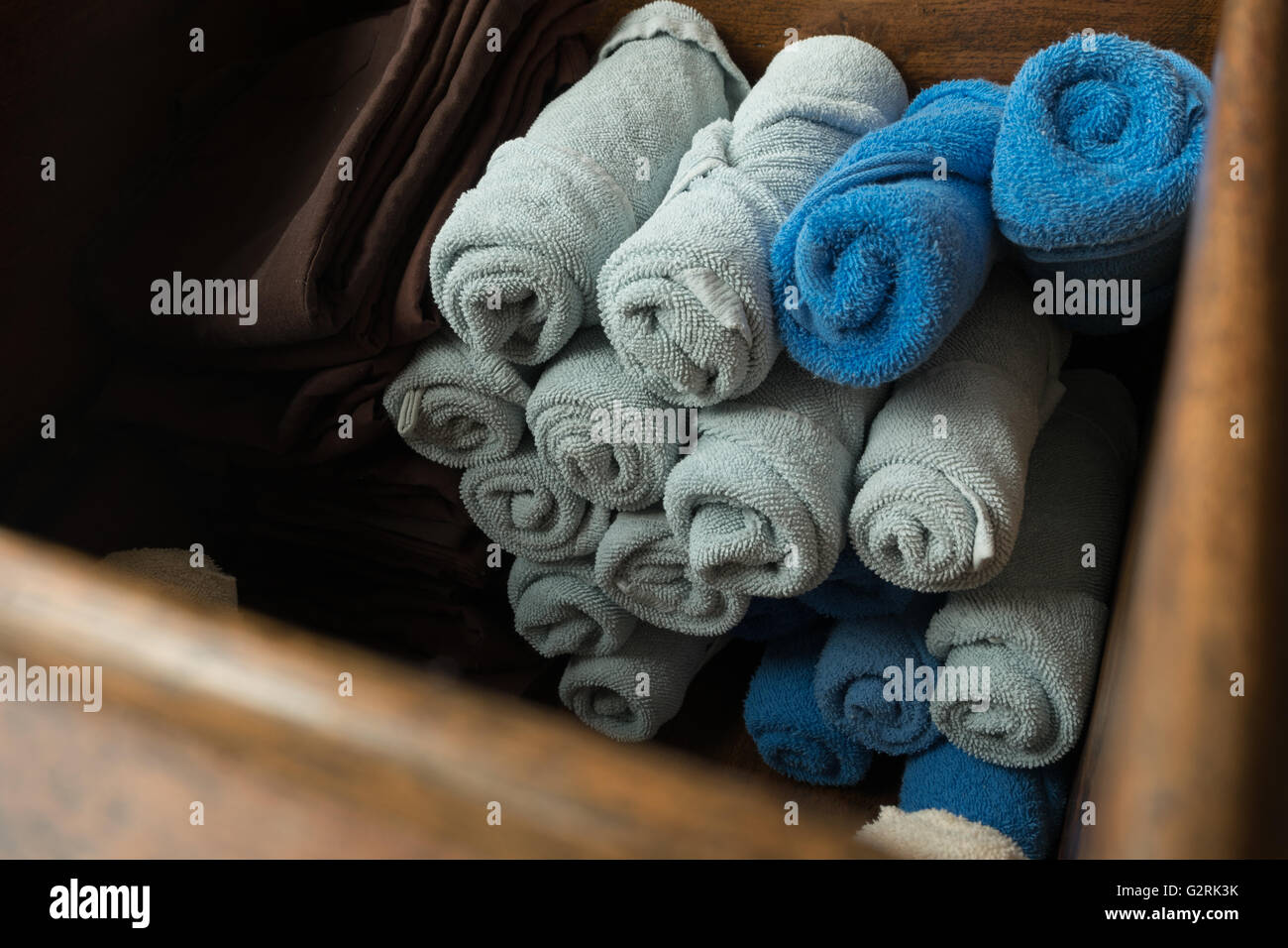 Bleu et gris clair roula spa massage serviette dans la boîte en bois. Banque D'Images