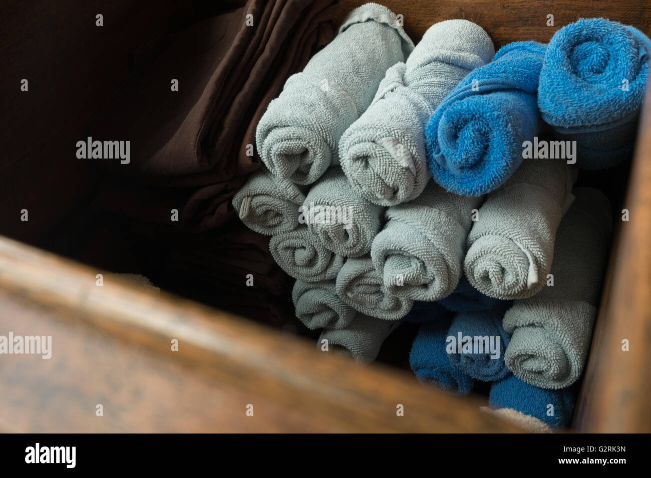 Bleu et gris clair roula spa massage serviette dans la boîte en bois. Banque D'Images