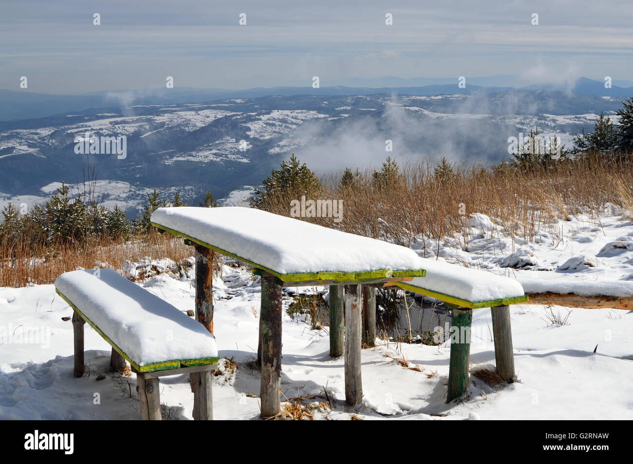 La neige a couvert deux vieux bancs en bois et une table, ensoleillée journée d'hiver de la Montagne Vitosha, large vue panoramique Banque D'Images