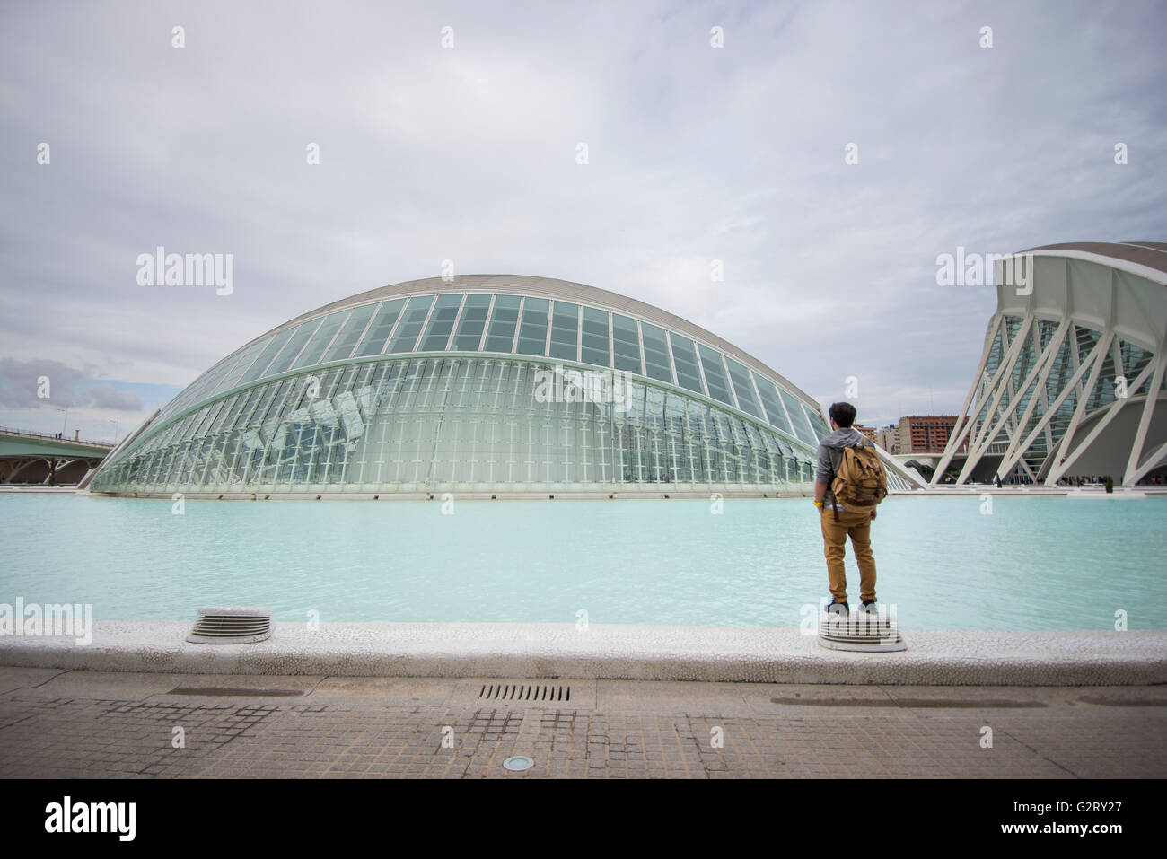 Un jeune homme debout à côté de la piscine de la Cité des Arts et des Sciences à la recherche de l' Hémisphère, Valence, Espagne. Banque D'Images