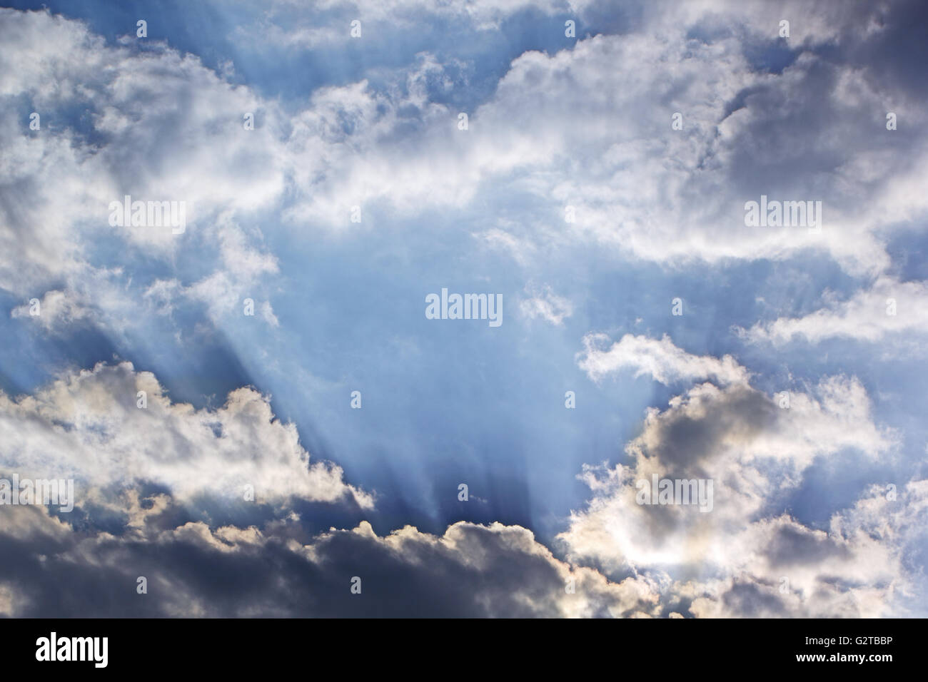 Les rayons du soleil qui traverse des nuages dans le ciel bleu Banque D'Images