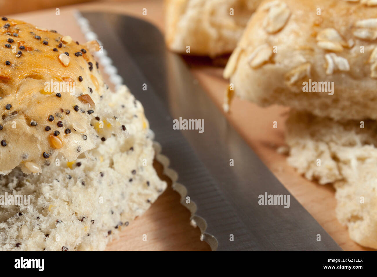 Petits pains d'avoine ensemencée fixant à côté d'un couteau sur un plan de travail de cuisine Banque D'Images