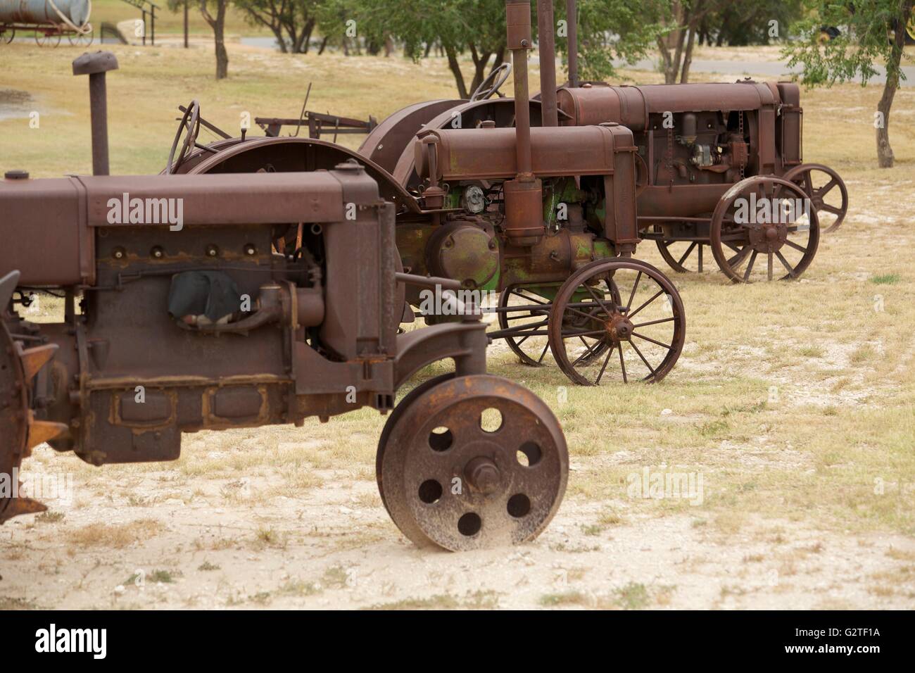 Rusty anciens tracteurs debout dans un champ. Banque D'Images