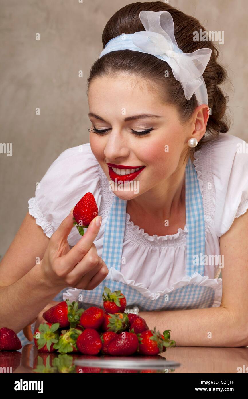 Un style rétro-girl eating fresh strawberries Banque D'Images