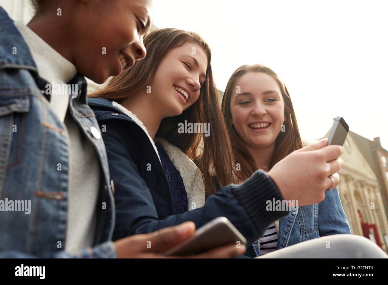 Les jeunes filles à l'aide de leur téléphone mobile en milieu urbain Banque D'Images