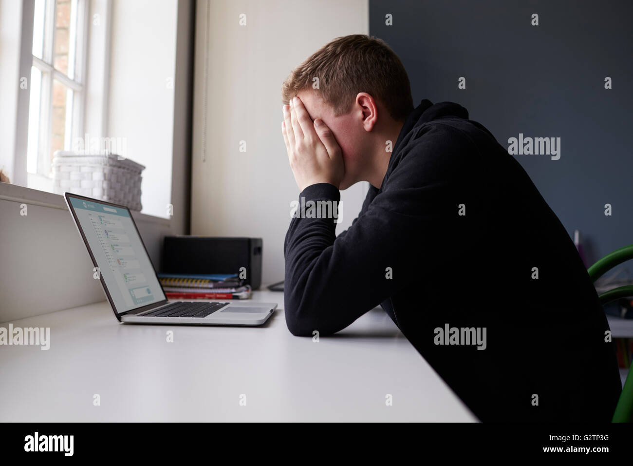 L'adolescence malheureuse victime de l'intimidation en ligne dans la chambre Banque D'Images