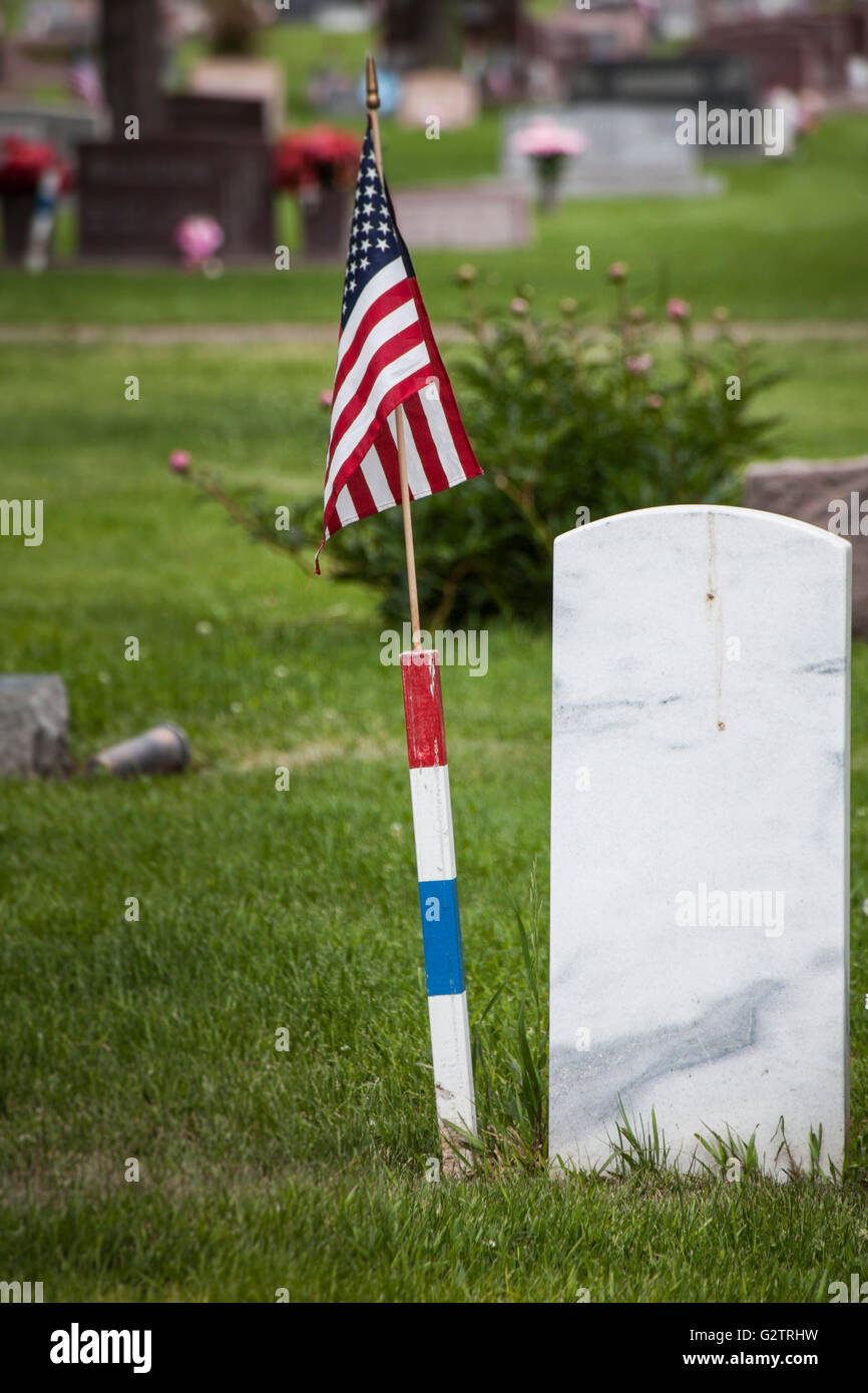 Vu de derrière, une pierre tombale en marbre massif, avec un drapeau américain à côté de l'identifier comme un vétéran militaire's grave. Banque D'Images