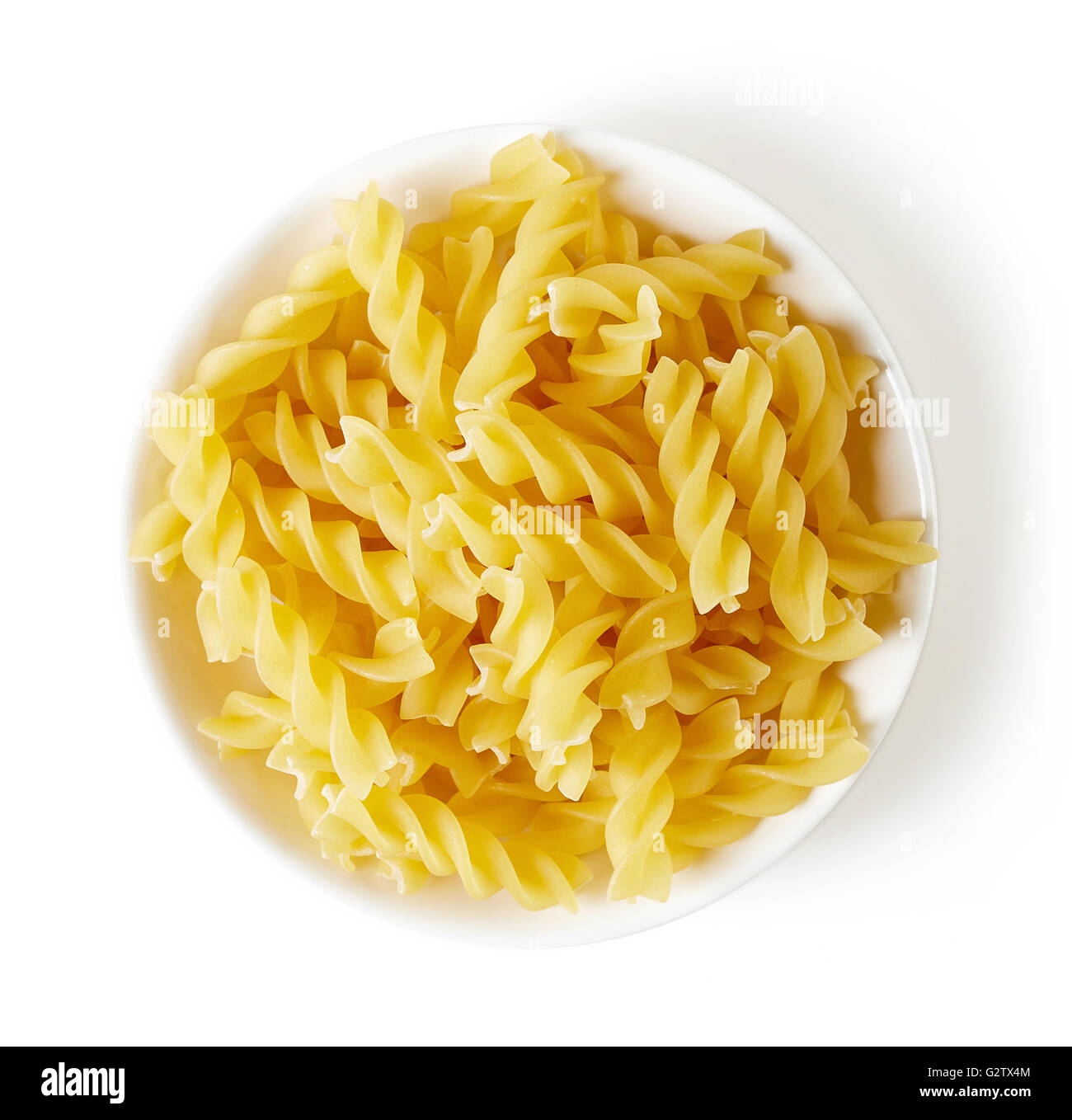 Dans un bol de pâtes en spirale, isolé sur fond blanc, vue du dessus Banque D'Images