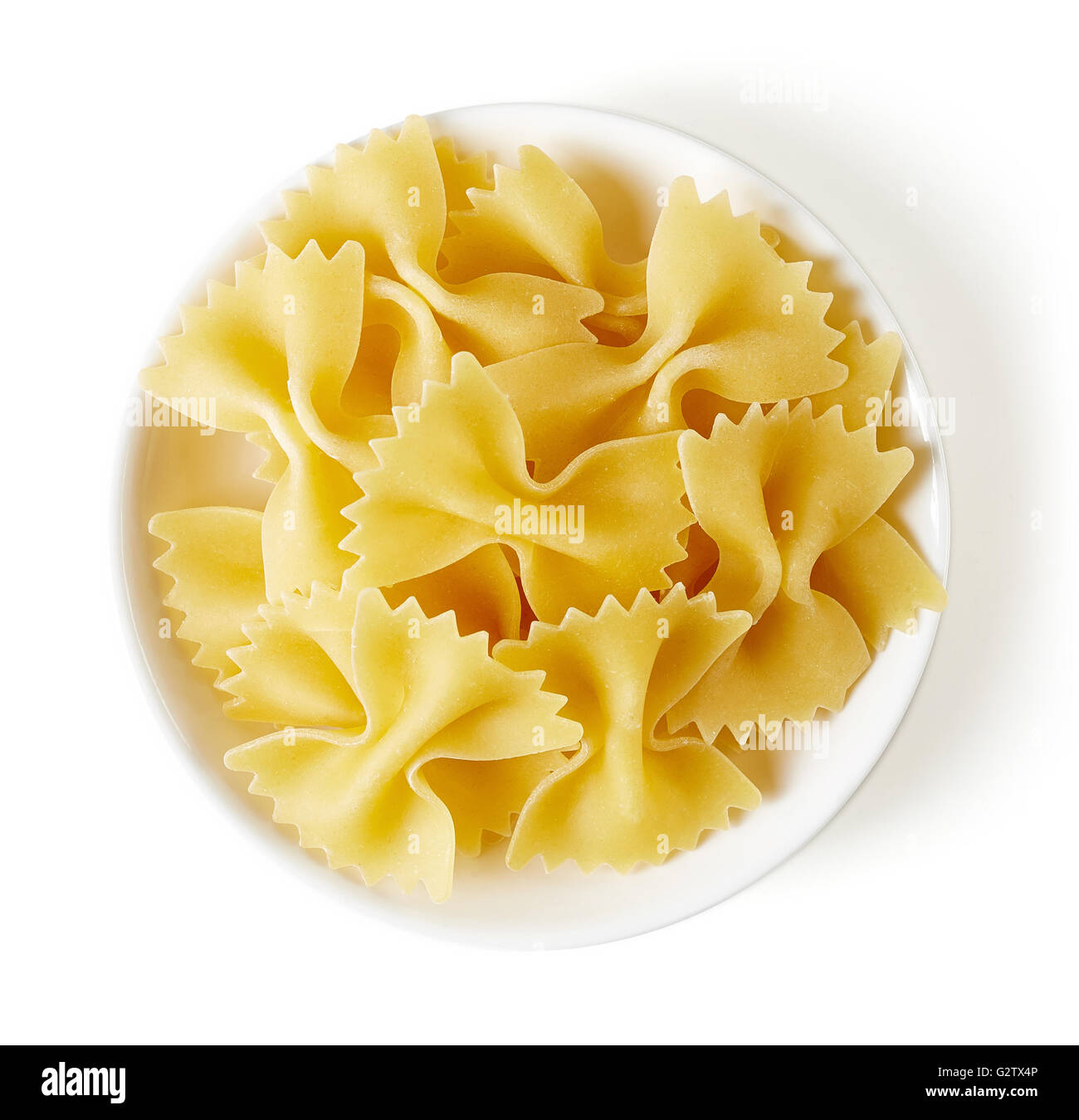 Dans un bol de pâtes papillon, isolé sur fond blanc, vue du dessus Banque D'Images