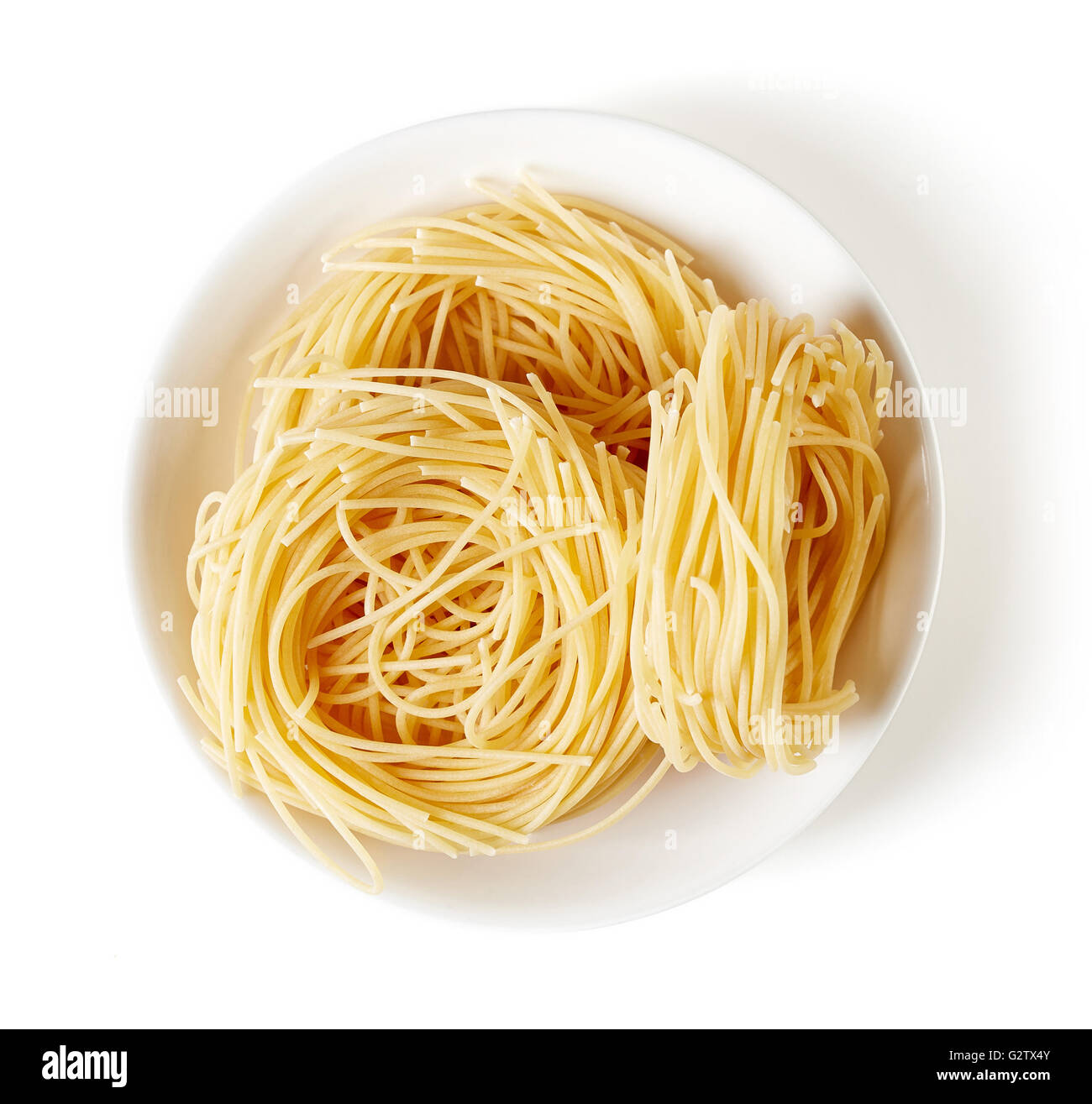 Nid de pâtes dans un bol, isolé sur fond blanc, vue du dessus Banque D'Images