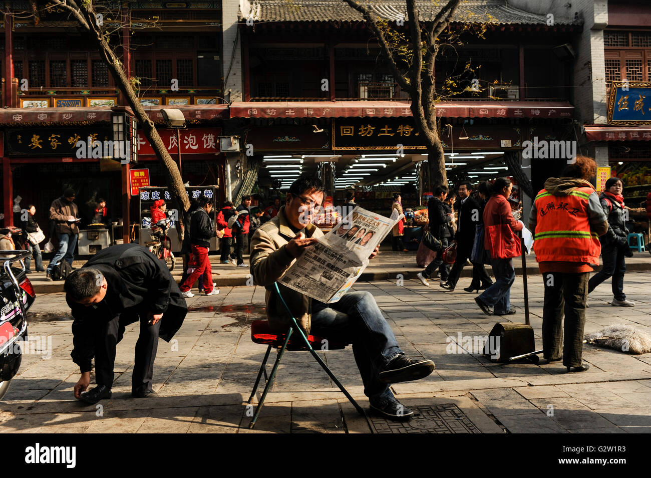 La Chine, Shaanxi Province, ville, rue commerçante et lecteur de journaux Banque D'Images