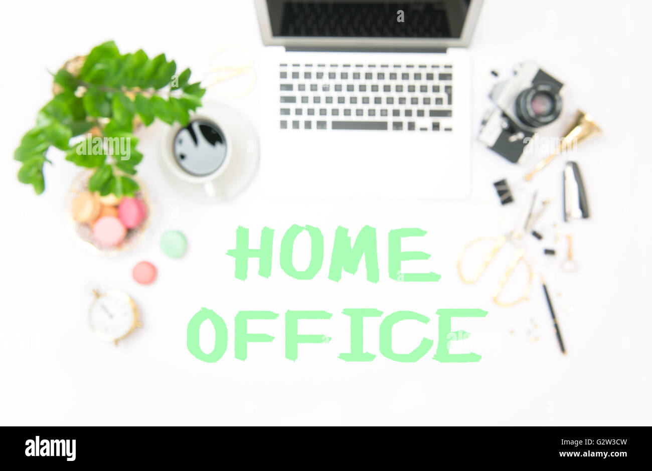 Lieu de travail avec ordinateur portable et des fournitures de bureau. Arrière-plan flou. Mise à plat des problèmes de mise au point. L'exemple de texte HOME OFFICE Banque D'Images