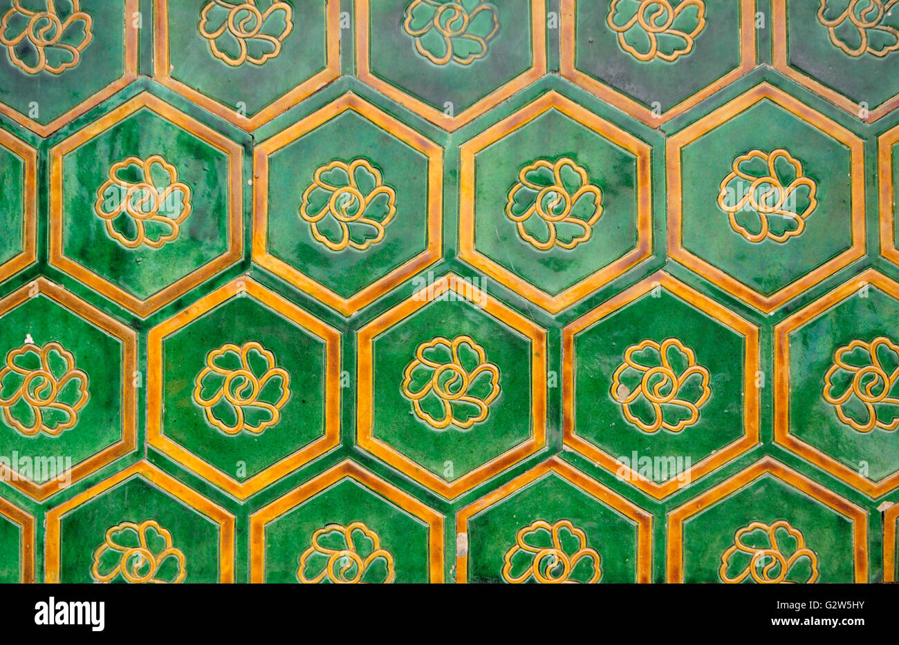 Tuiles vernissées vert avec une fleur de lotus dans le fond de chaque centre dans la Cité Interdite à Beijing en Chine. Banque D'Images