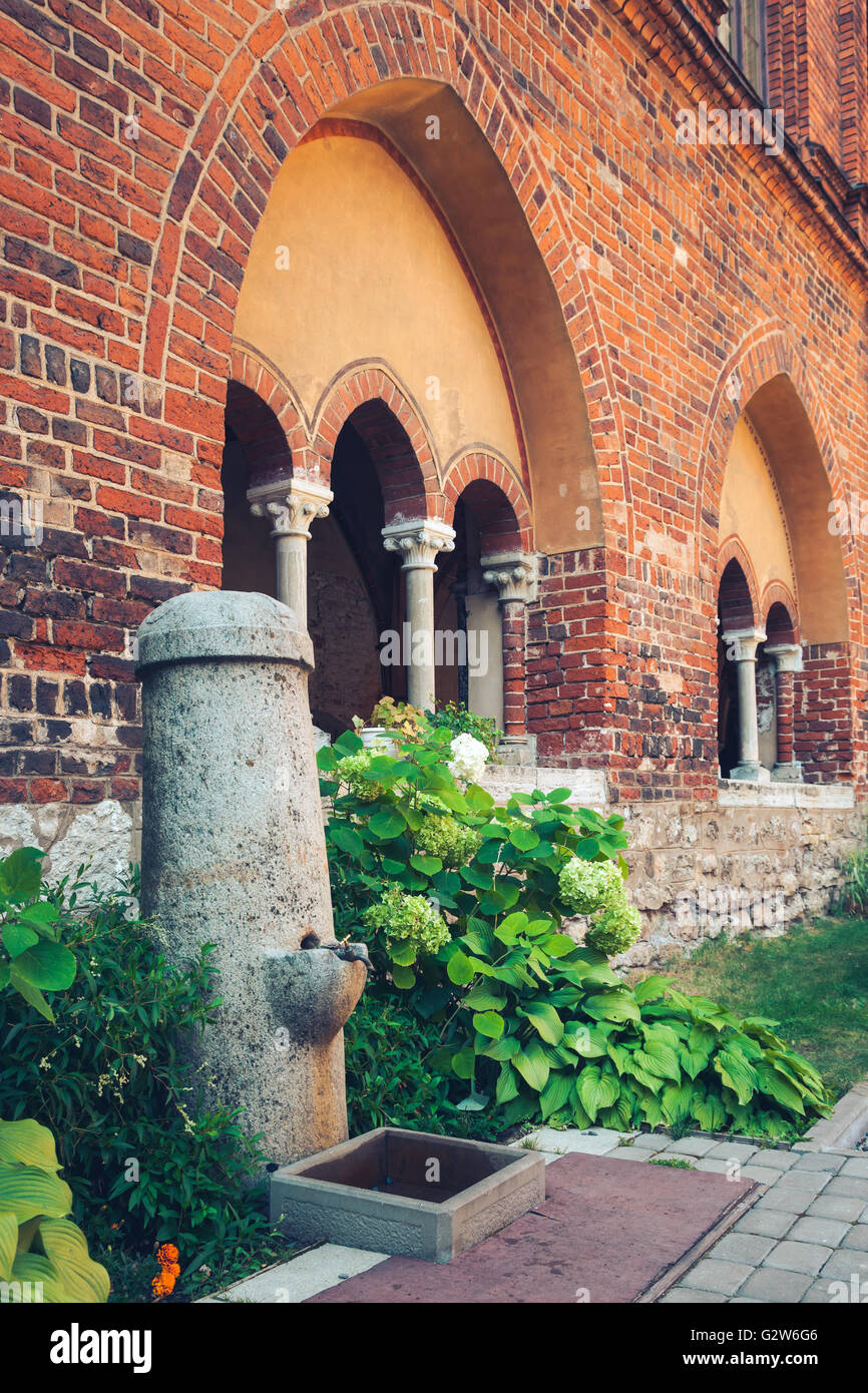 Fontaine publique avec l'eau qui coule à l'intérieur de la cour intérieure de la cathédrale de Riga. Riga, Lettonie. Banque D'Images