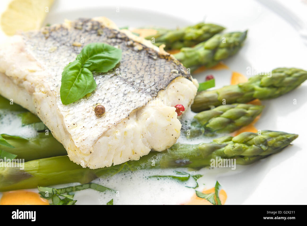 Filet de poisson avec sauce mousse d'asperges, macro, soft focus Banque D'Images