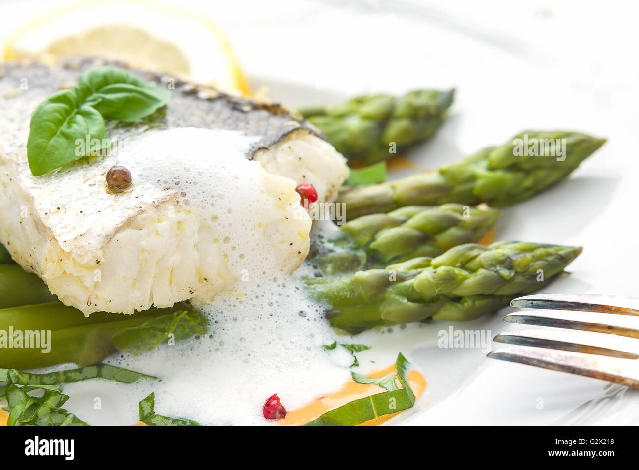 Filet de poisson aux asperges sauce mousse et la fourche, soft focus Banque D'Images