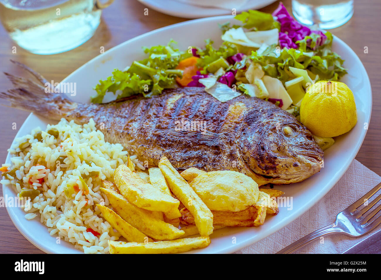 Dorade avec pomme de terre, riz et salade, méditerranéenne Banque D'Images
