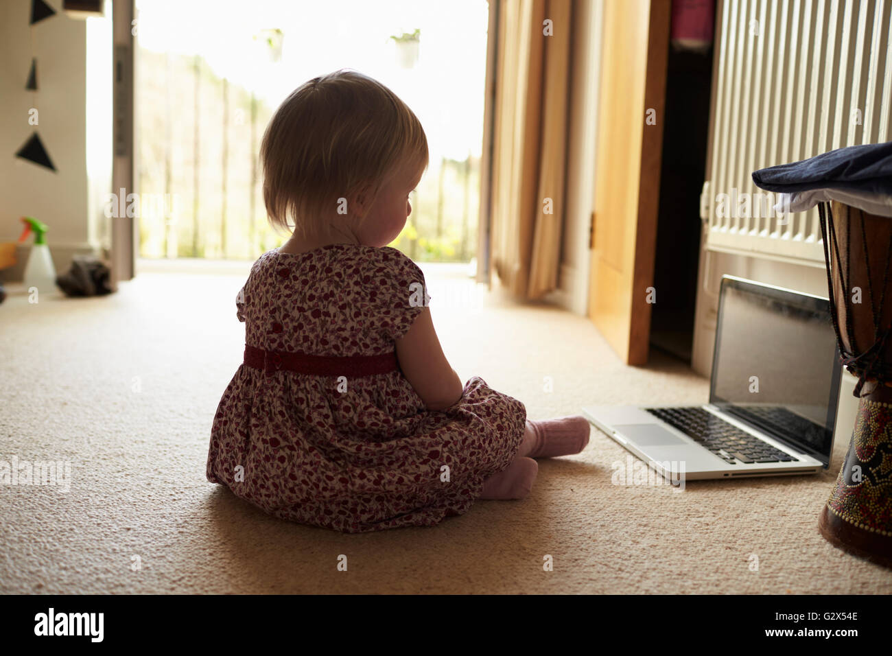 Jeune fille assis à la maison regarder la vidéo sur l'ordinateur portable Banque D'Images