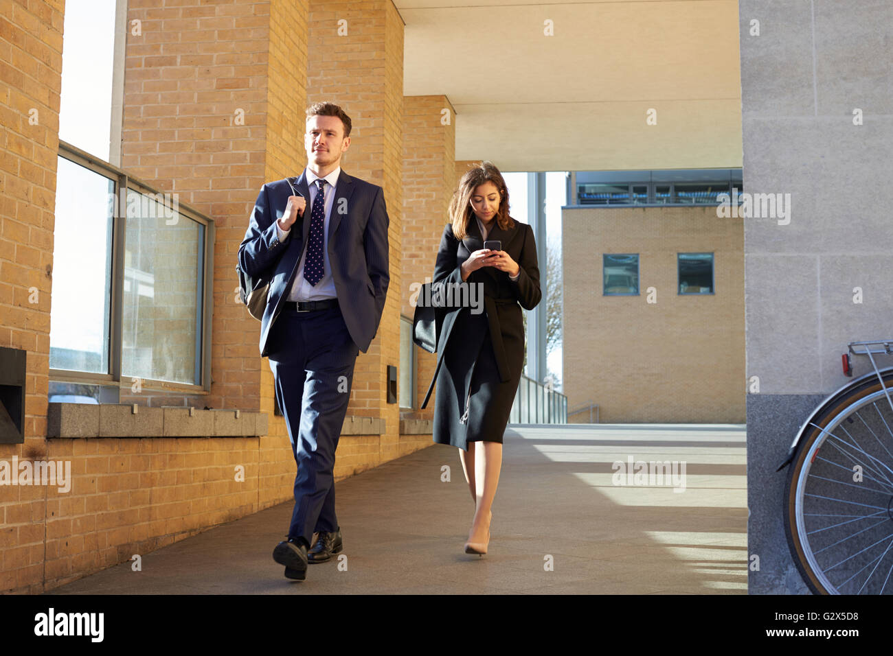 Businesswoman lit les messages texte sur chemin du travail Banque D'Images