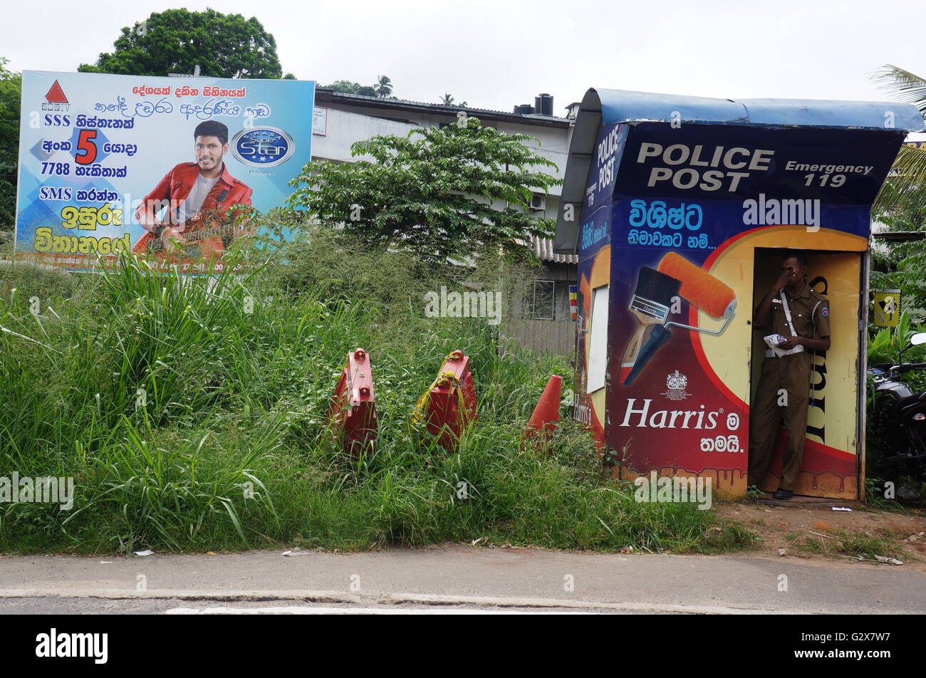 Un policier est debout dans un poste de police stand le long de la voie ferrée dans la région de Kandy, Sri Lanka. Banque D'Images