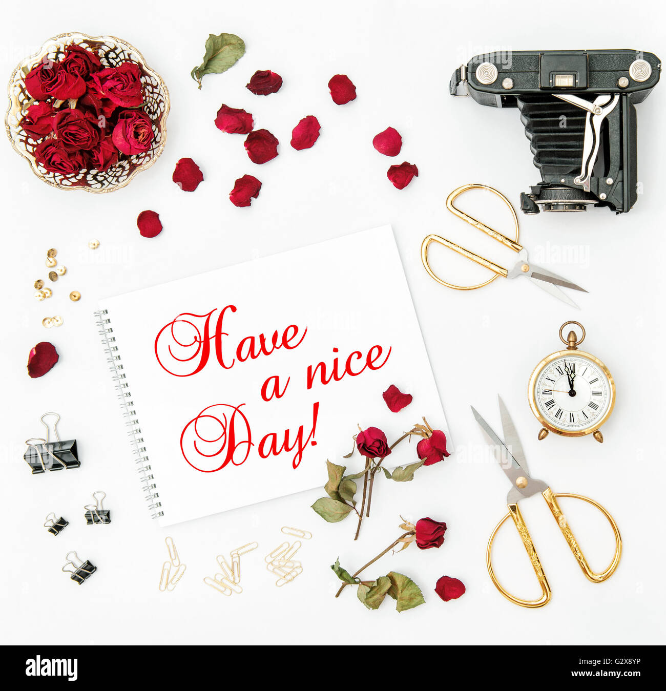 Mise à plat avec sketchbook, Red Rose, vintage camera, ciseaux sur fond blanc. Les fleurs rouges. Have a nice day ! Banque D'Images