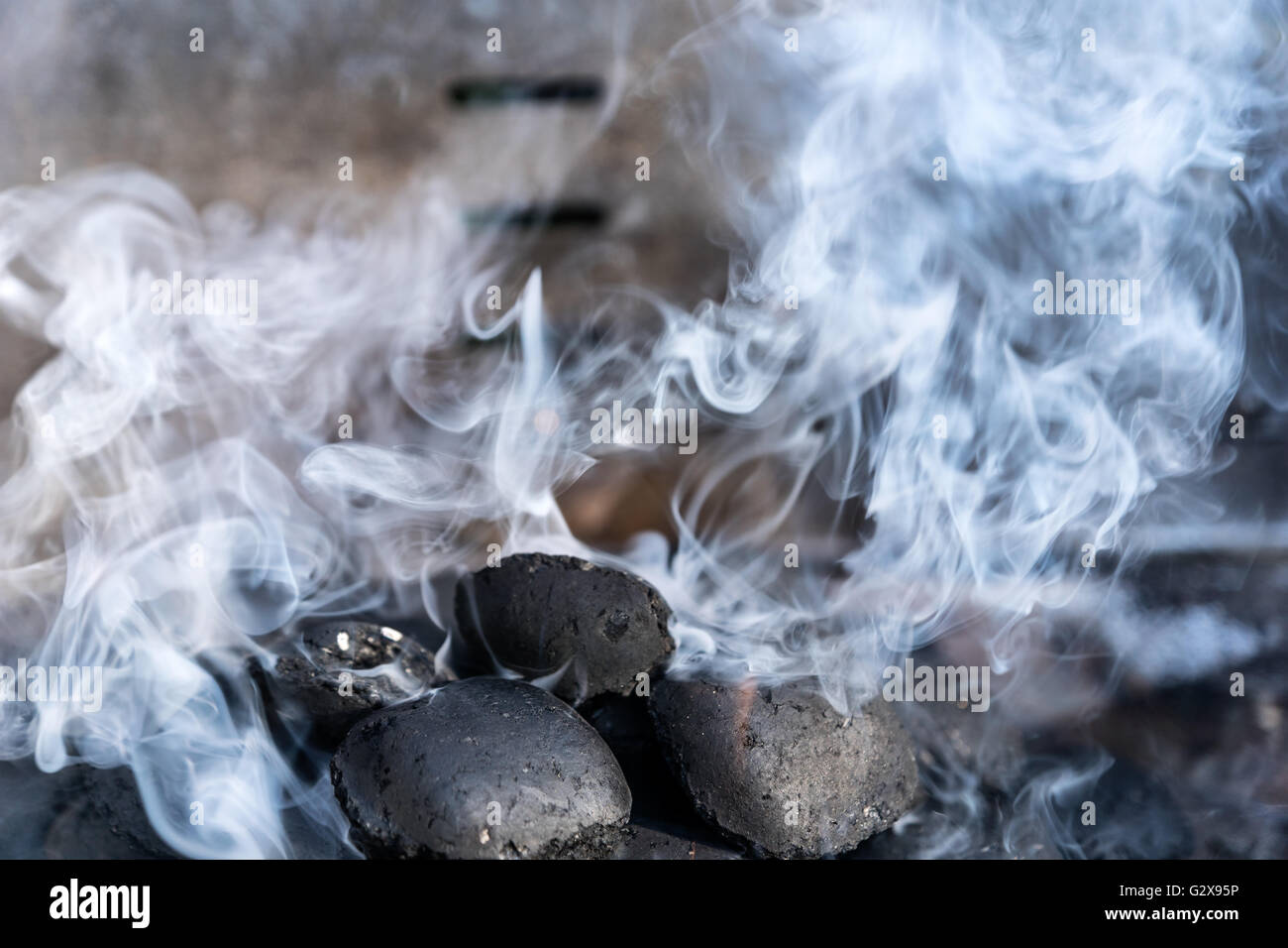 Lumière de charbons dans un barbecue avec beaucoup de fumée - sélection focus, réduire la profondeur de champ Banque D'Images